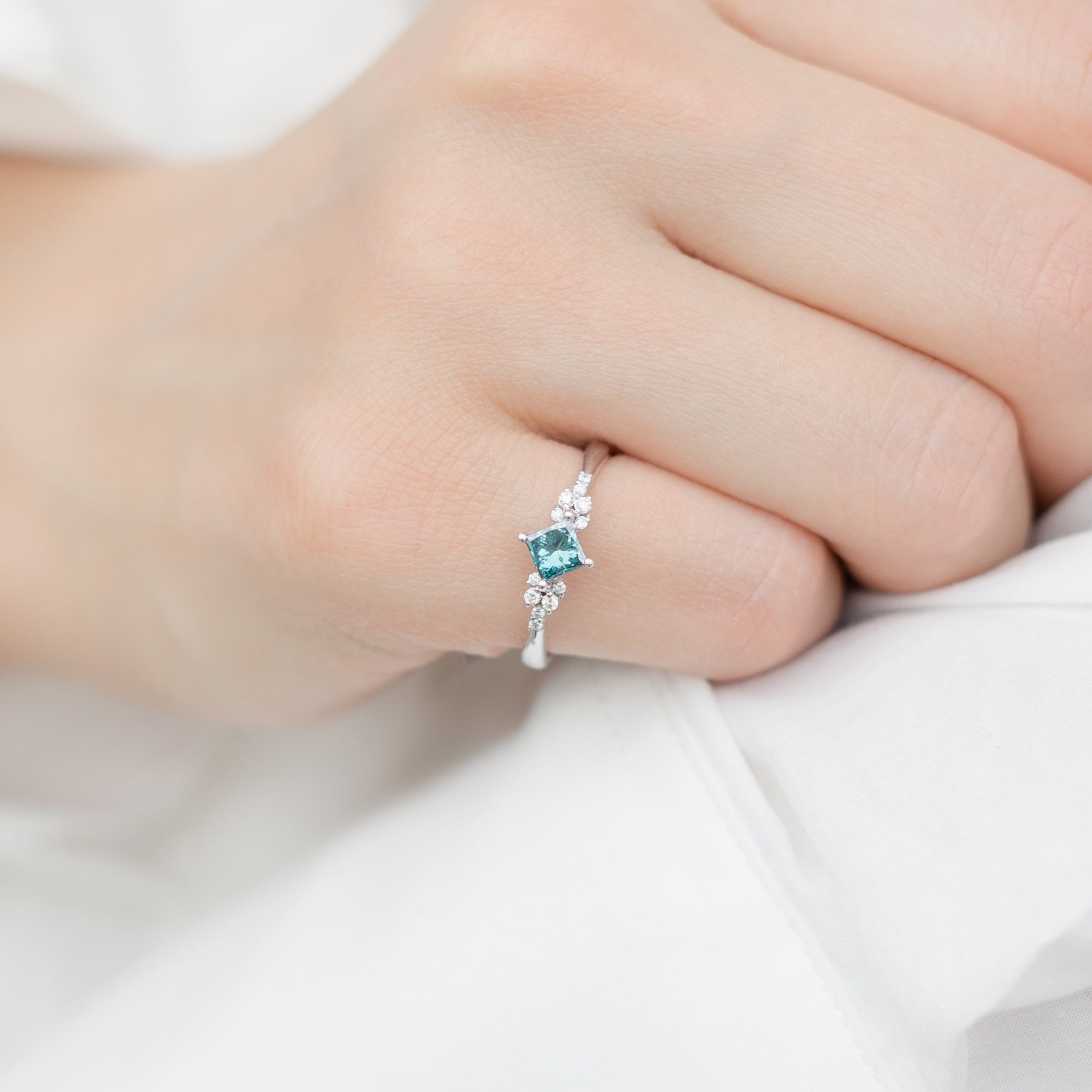14 Karat Goldring mit blauem Diamanten im Prinzessschliff und Diamanten